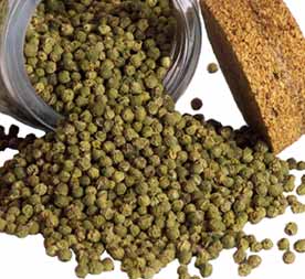 Bulk dried green peppercorns — unripe Piper nigrum berries with mild, fresh, grassy flavor